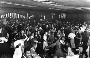 Interno del Savoy Ballroom ad Harlem con la pista da ballo affollata di ballerini di  Lindy Hop durante la Swing Era